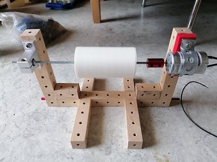 Selbstgebauter Motor mit weißer Rolle auf Holzgestell