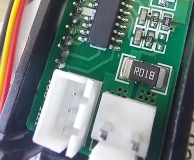 Nahaufnahme einer grünen Leiterplatte mit elektronischen Bauteilen