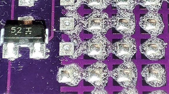 Nahaufnahme von Lötstellen auf einer violetten Leiterplatte