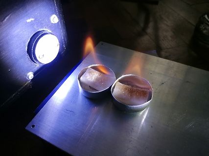 Teelichter auf Metallplatte unter Lichtquelle