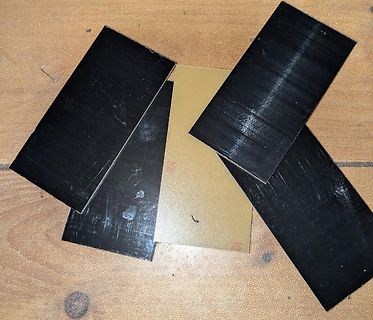 Schwarze und goldene Metallplatten auf Holzuntergrund