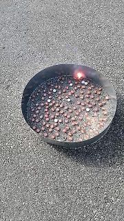 Metallschale mit kleinen Bauteilen auf Asphalt