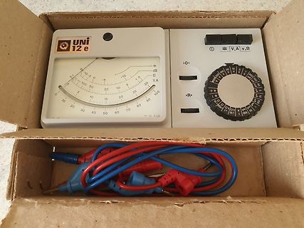 Analoges Multimeter in einem Karton mit Messkabeln