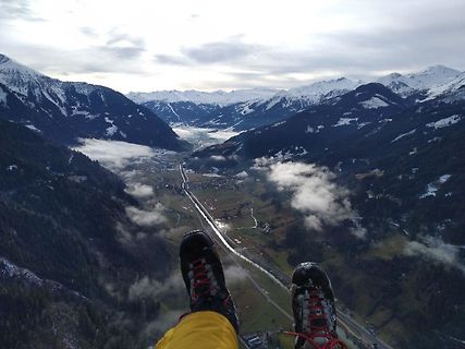 Blick aus der Höhe auf ein Tal mit Bergen