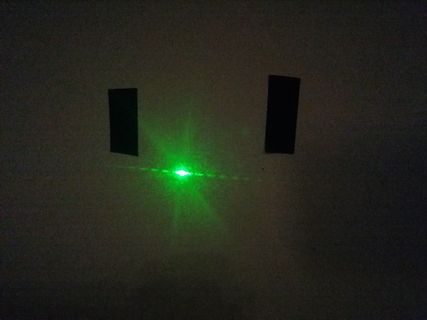 Grüner Laserstrahl durch zwei Schlitze