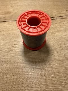 Spule mit Draht auf roter Kunststoffspule