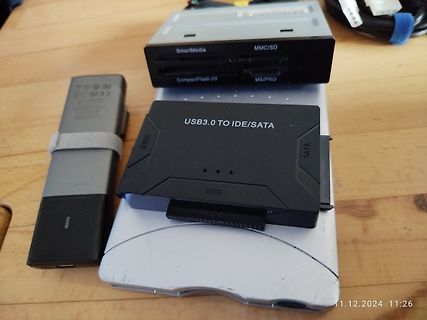USB-Adapter und Speicherkartenleser auf einem silbernen Gehäuse