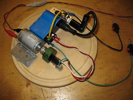 Elektrischer Aufbau mit Motor und Netzteil auf Holzbrett