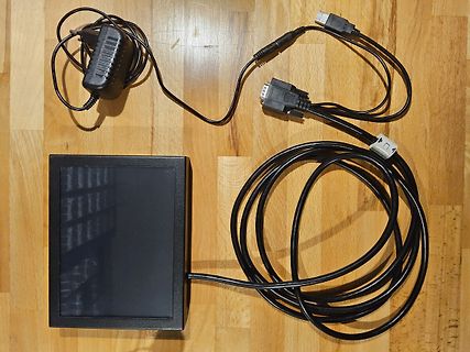 Netzteil, Display und diverse Kabel auf Holzuntergrund