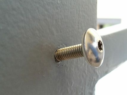 Metallschraube in grauer Oberfläche