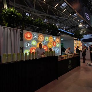 Messestand mit Donut-Grafiken und Chip 1 Exchange Tresen