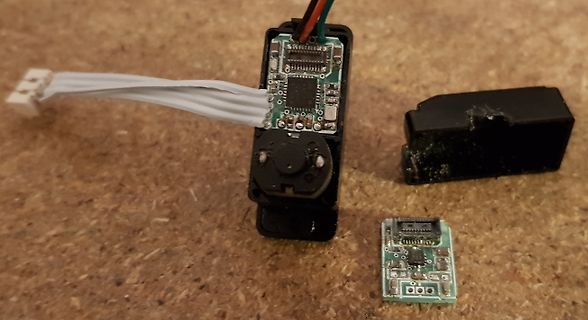 Zerlegte Elektronikkomponente mit Leiterplatte und Flachbandkabel