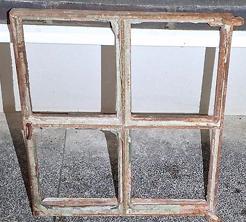 Rostiger Metallrahmen mit vier Fensterscheiben-Aussparungen