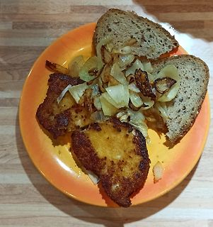 Essen auf einem orangefarbenen Teller mit Brot und Zwiebeln