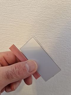 Hand hält einen silbernen Gegenstand