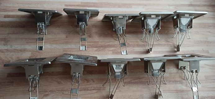 Zehn Metallhalterungen auf Holzuntergrund