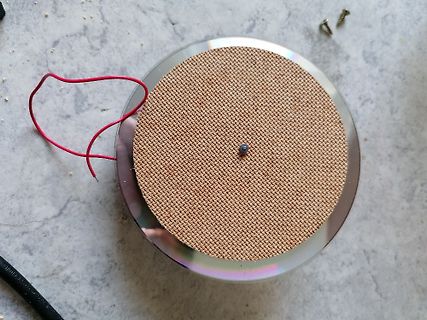 Rundes Bauteil mit Gewebestruktur und roten Kabeln