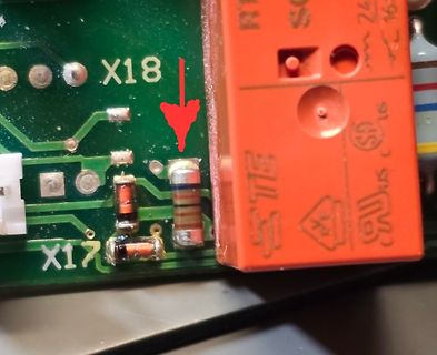 Nahaufnahme einer Leiterplatte mit Bauteilen und rotem Stecker