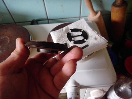 Hand hält ein Bauteil vor einem weißen Gerät