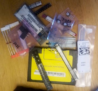 Verschiedene elektronische Bauteile in Plastikbeuteln auf Holzuntergrund
