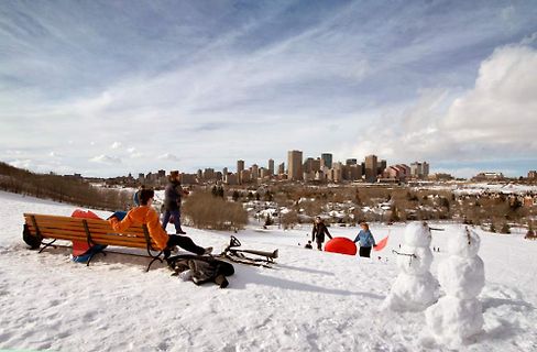 Menschen und Schneemänner in einer verschneiten Stadtlandschaft