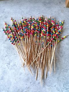 Bunte Holzstäbchen mit Perlen