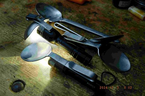 Taschenlampe und Löffel auf Holztisch