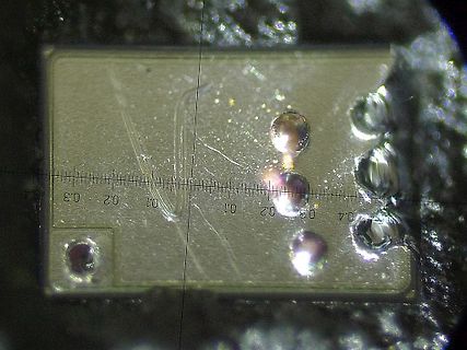 Mikroskopische Aufnahme einer Leiterplatte mit Skala