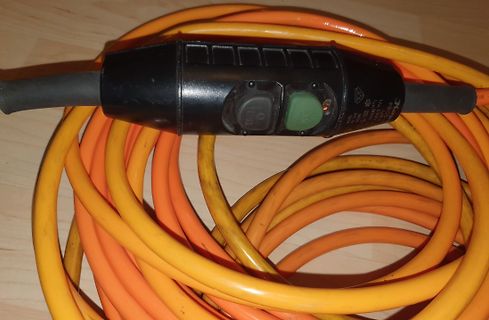 Oranges Verlängerungskabel mit schwarzem Schaltergehäuse