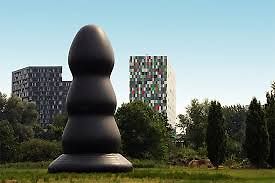 Große schwarze Skulptur vor Gebäuden