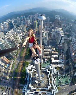 Personen auf einem Selfie-Stick auf einem Hochhaus