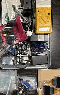 Verschiedene Elektronikbauteile, Platinen und ein Multimeter
