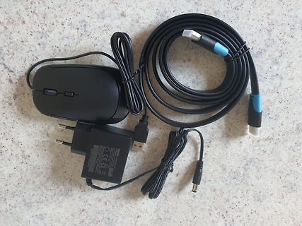 Computermaus, Netzteil und USB-Kabel auf Tisch