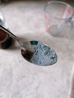 Silberfarbenes Pulver auf einem Löffel