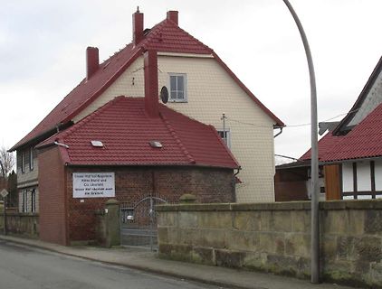 Haus mit Schild und Mauer