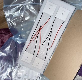 Vier weiße Sensoren mit roten und schwarzen Kabeln