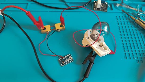 Elektrischer Aufbau mit Glühbirne, Platine und Krokodilklemmen