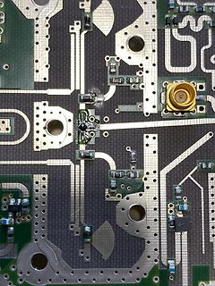 Nahaufnahme einer Leiterplatte mit SMD-Bauteilen und SMA-Buchse