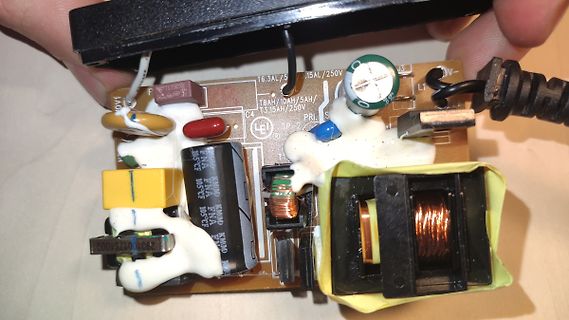 Geöffnete Platine eines Netzteils mit Silikonmasse