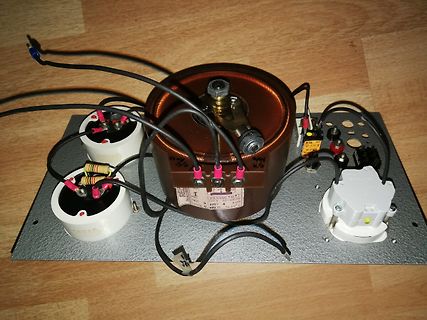 Aufbau eines Transformators mit Kondensatoren auf Metallplatte