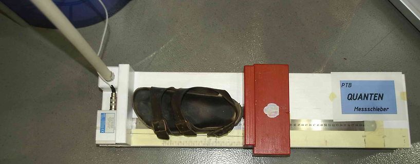 Schuh auf einem Messschieber