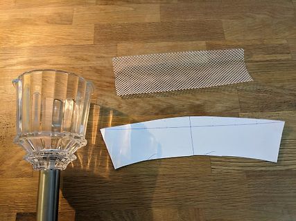 Kristallglas, Netzgewebe und Papiervorlage auf Holztisch