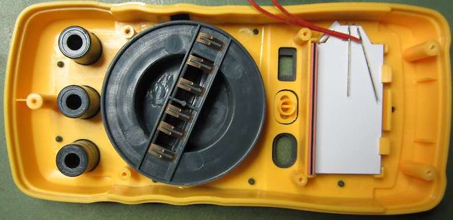 Innenansicht eines gelben Kunststoffgehäuses mit Batteriefach