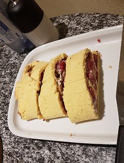 Aufgeschnittener Erdbeerkuchen auf einem weißen Teller