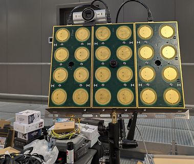 Drei grüne Leiterplatten mit kreisförmigen Goldflächen auf Stativ