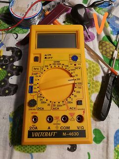 Gelbes Multimeter auf Werkstattunterlage