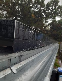 Nasse schwarze Bauteile auf Metallprofil
