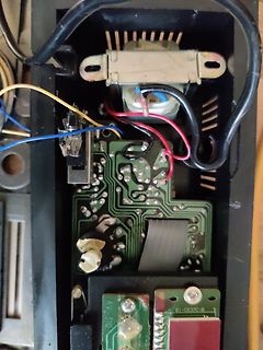 Innenansicht eines geöffneten elektronischen Geräts mit Transformator und Platine