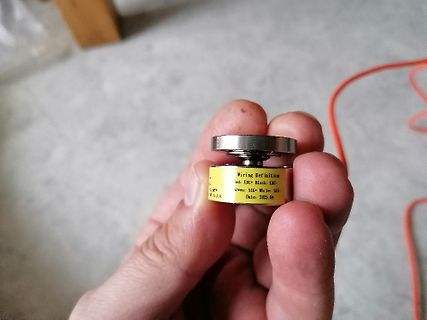 Hand hält ein Bauteil mit Beschriftung