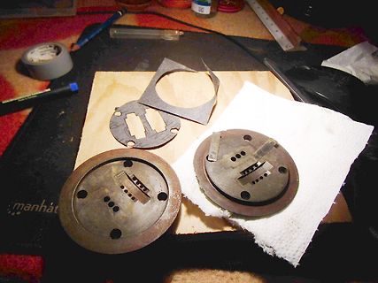 Metallische Bauteile auf Holzbrett und Werkstattutensilien